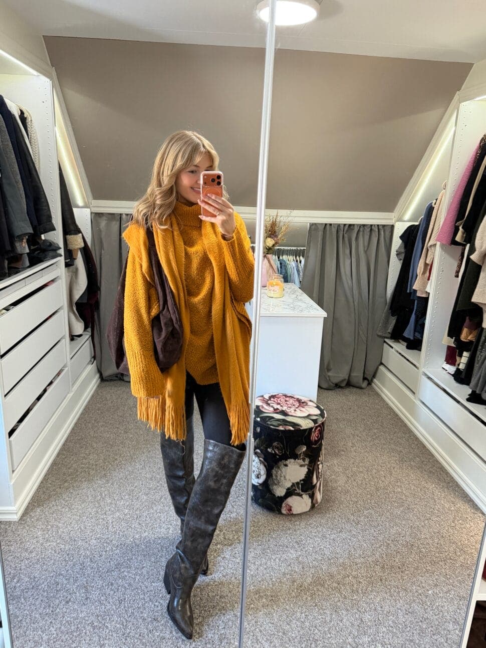 Ella in an orange poncho and matching scarf, with grey over-the-knee boots